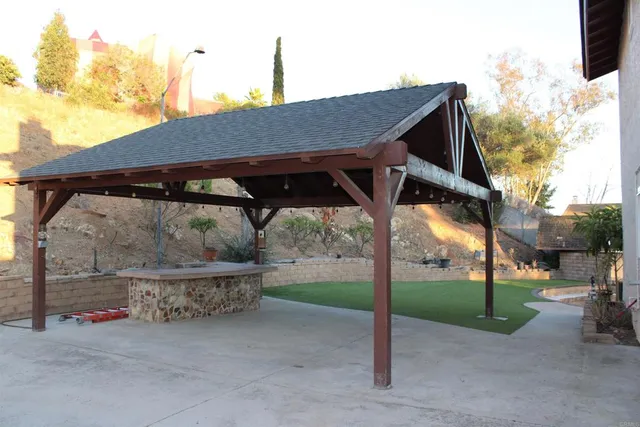 a backyard of a house with barbeque oven table and chairs