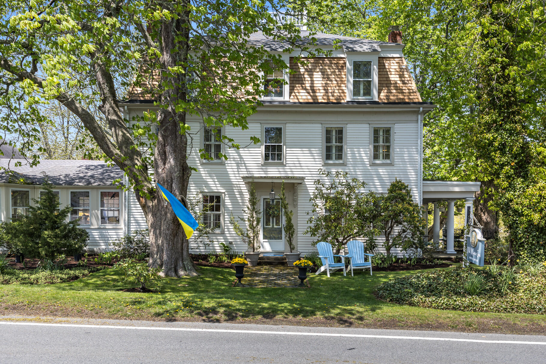 a front view of a house with a yard and potted plants