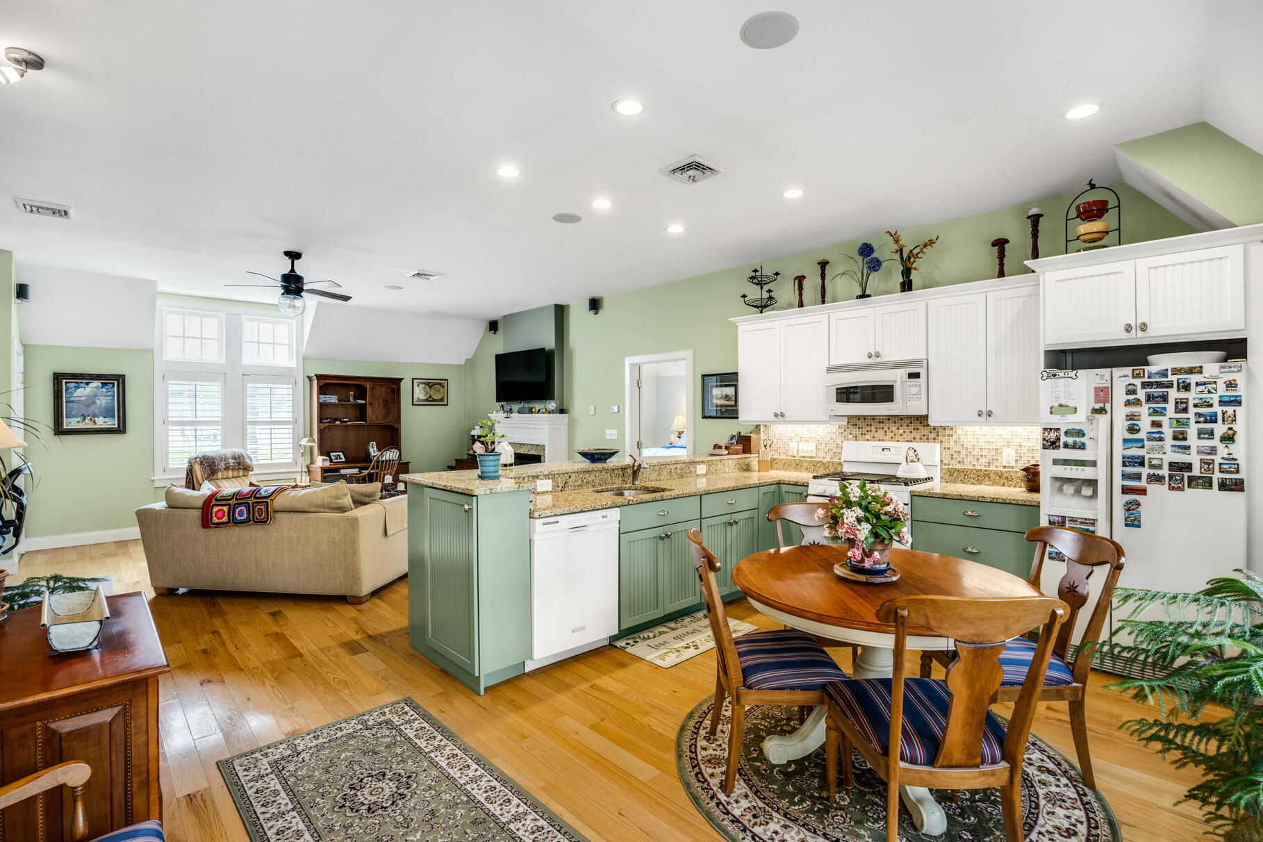 1861 Main Street Brewster, MA 02631 - Photo 45 of 65 a open dining room with stainless steel appliances kitchen island granite countertop a dining table chairs and couches with wooden floor