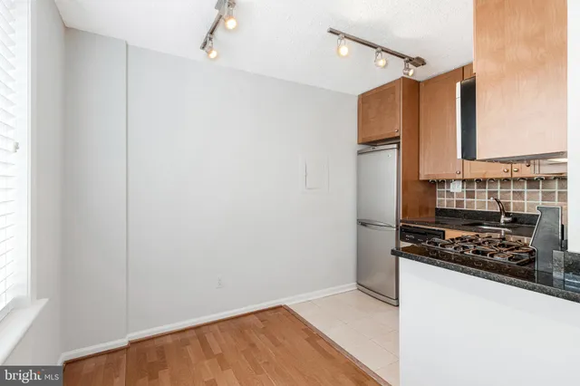 a kitchen with appliances a sink and cabinets