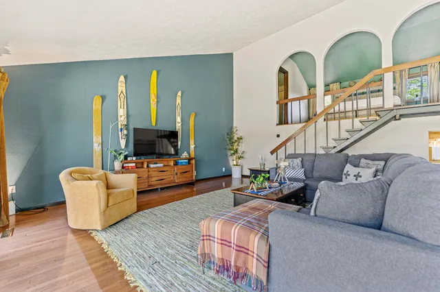 a living room with furniture and a wooden floor