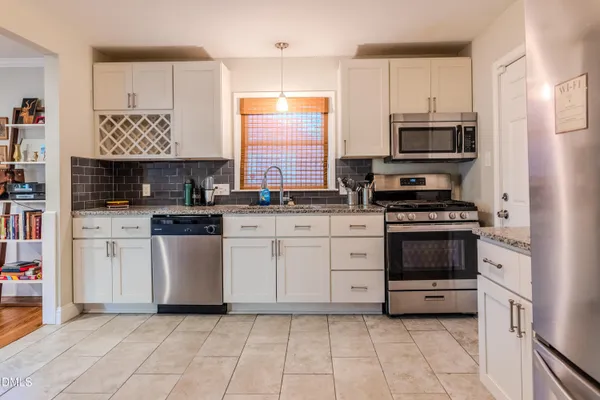 a kitchen with stainless steel appliances a stove sink and white cabinets