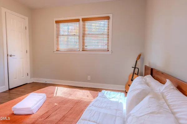 a bed sitting in a bedroom next to a window