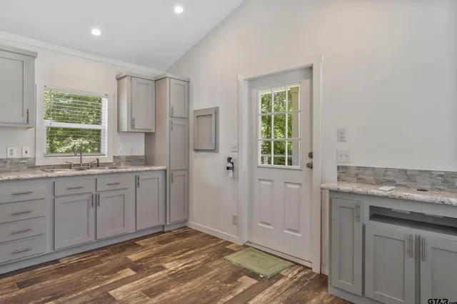 a kitchen with granite countertop cabinets appliances and a window