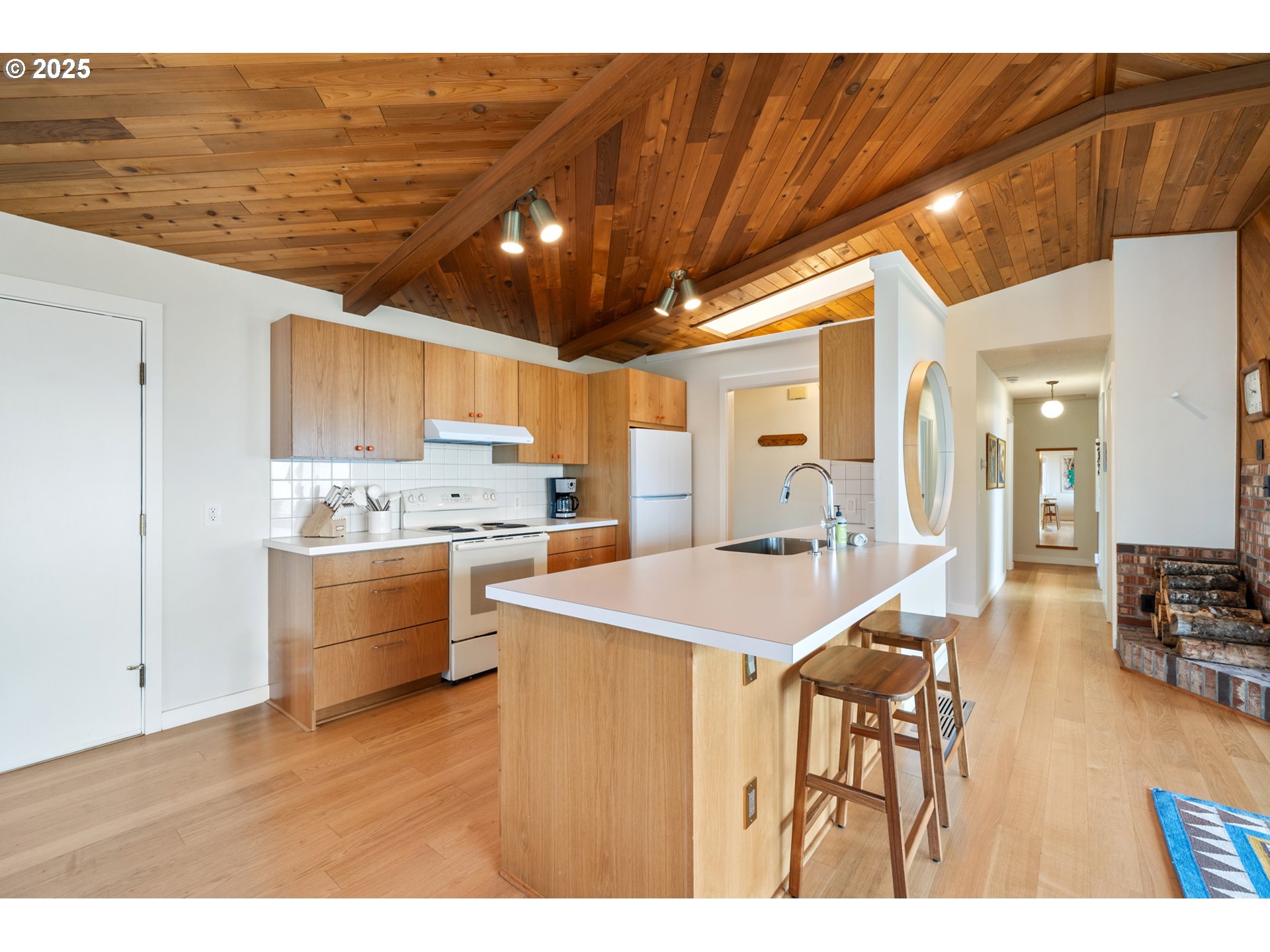 1100 Arthurs Road Oceanside, OR 97141 - Photo 22 of 48 a kitchen with a table chairs refrigerator and cabinets