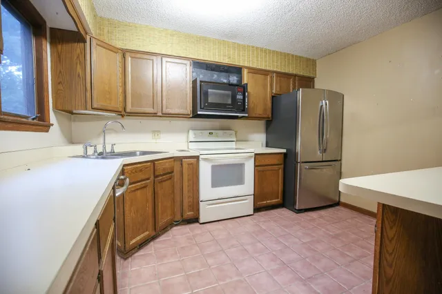 a kitchen with stainless steel appliances a refrigerator sink and cabinets