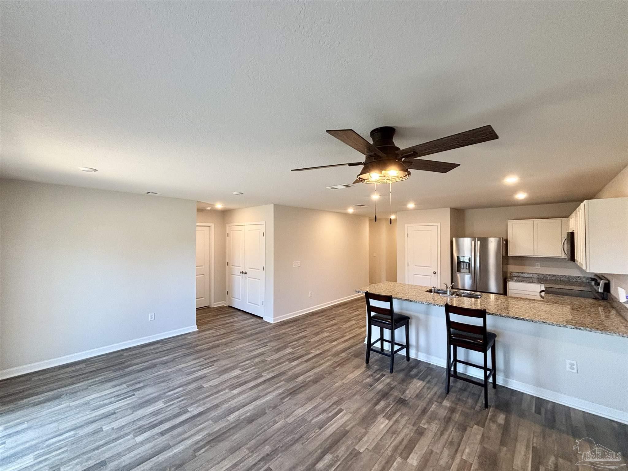 2164 Pineview Church Road Jay, FL 32565 - Photo 4 of 24 a view of a kitchen with wooden floor and a ceiling fan