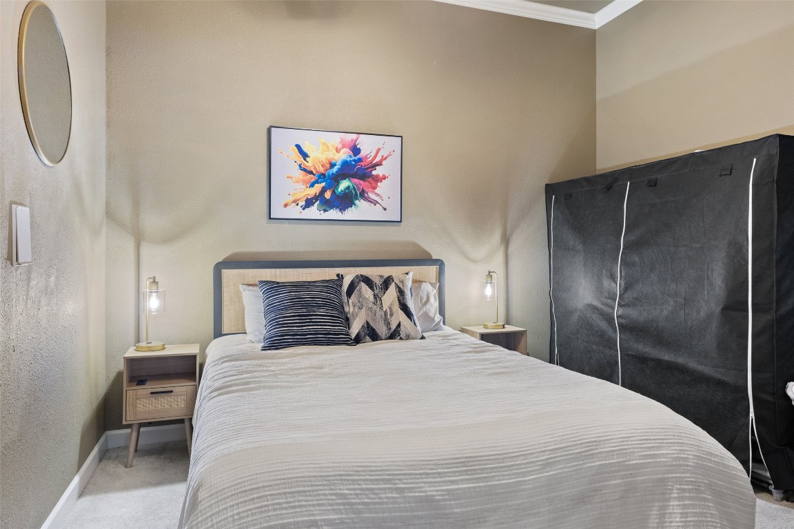 118 Lido Street Austin, TX 78734 - Photo 31 of 40 a bedroom with a large bed and a chandelier