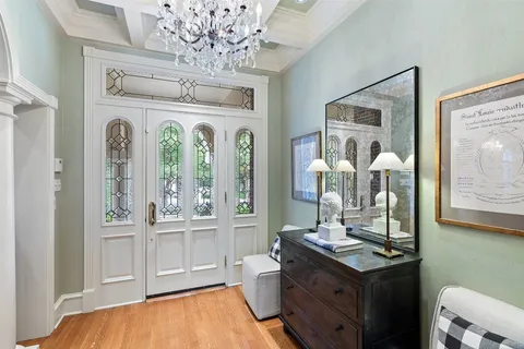 a dining room with wooden floor a chandelier a wooden table and chairs