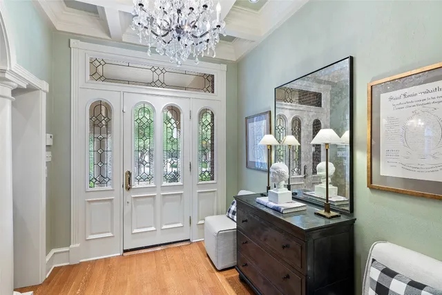 a dining room with wooden floor a chandelier a wooden table and chairs