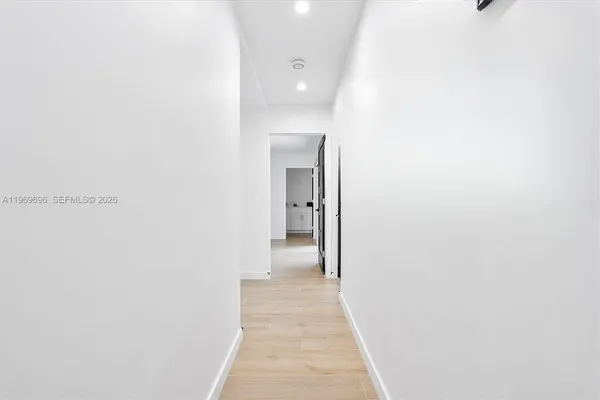 a view of a hallway with wooden floor