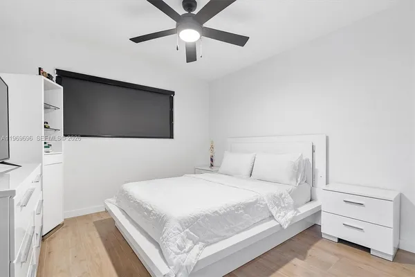 a bedroom with a bed and a flat tv screen on dresser