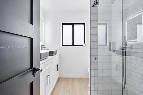 a bathroom with a double vanity sink a mirror and a shower