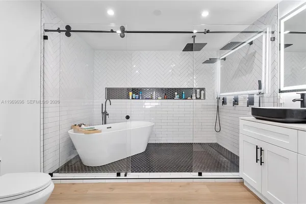 a bathroom with a sink a toilet and shower