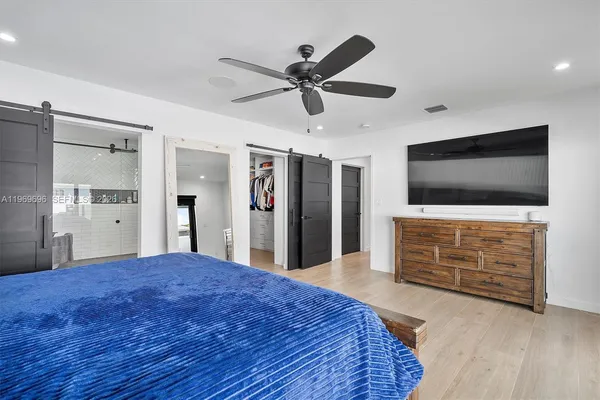 a bedroom with a bed and a flat screen tv