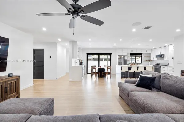 a living room with furniture and kitchen view