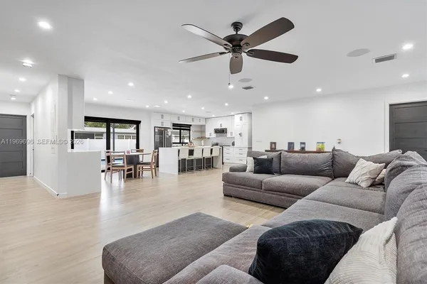 a living room with furniture and kitchen view