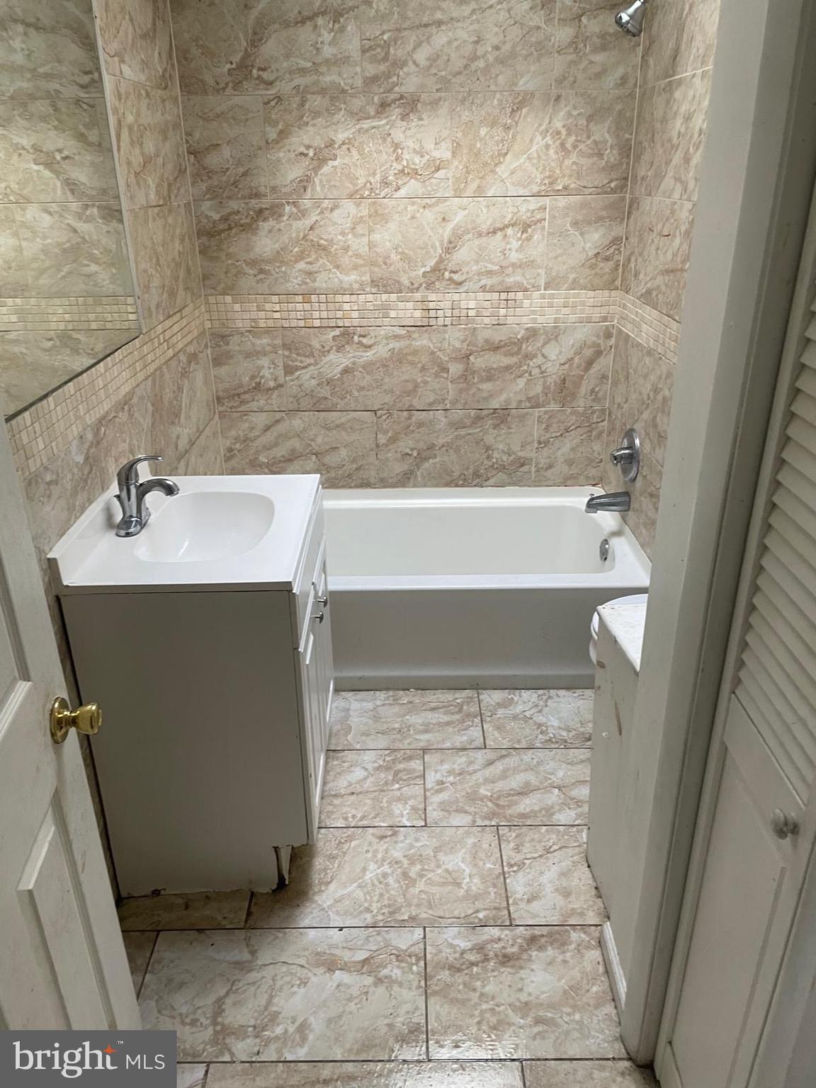 931 Kenmore Road Philadelphia, PA 19151 - Photo 6 of 11 a bathroom with a sink a toilet and bathtub