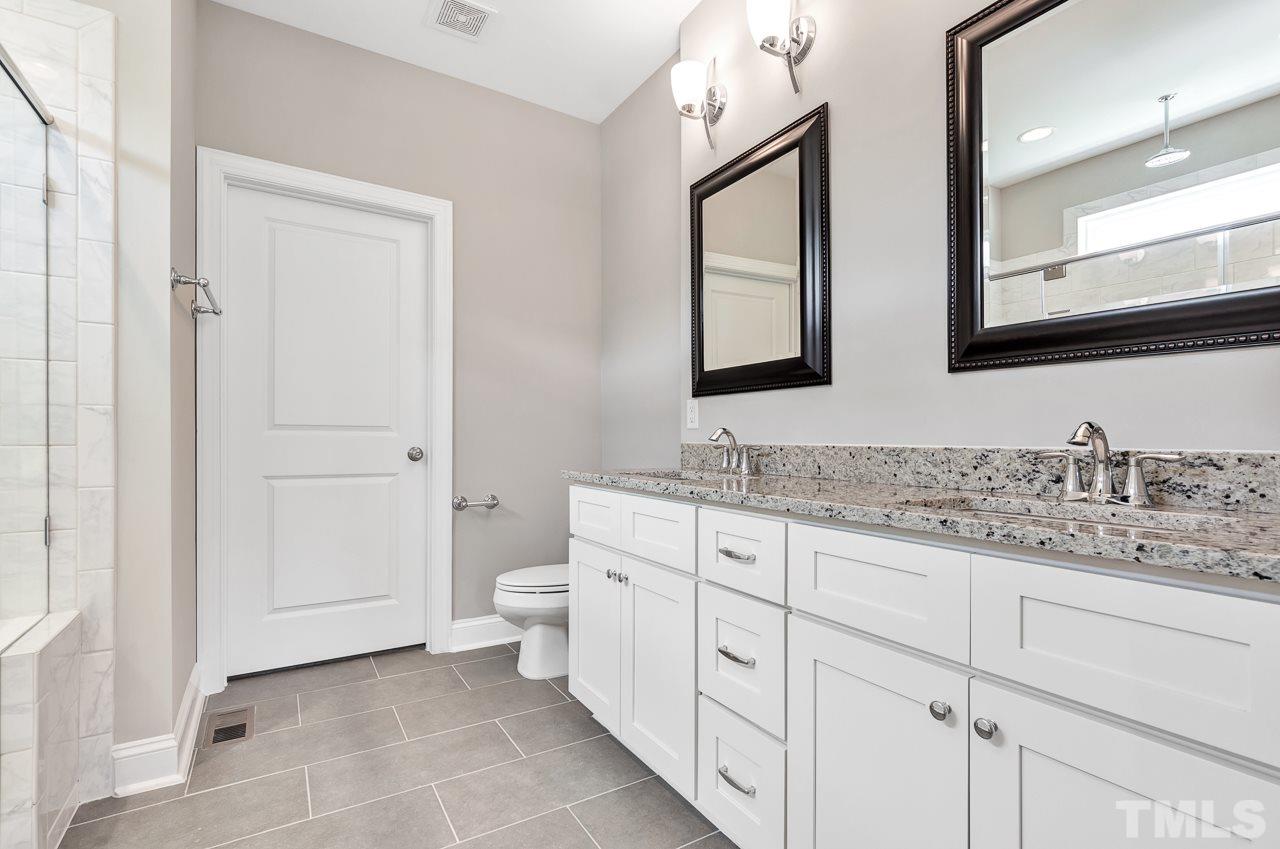 6733 Dwight Rowland Road Willow Spring, NC 27592 - Photo 16 of 25 Transom window overlooks the huge oversized tiled 2 seater shower with double sinks and d walk in closet
