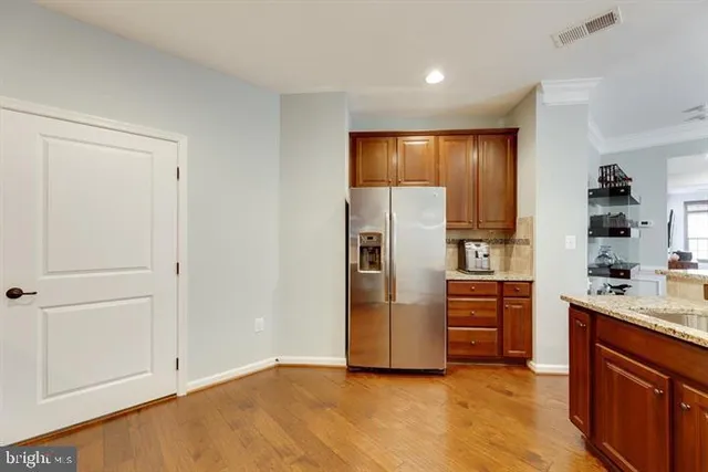 a kitchen with stainless steel appliances granite countertop a refrigerator and a stove top oven