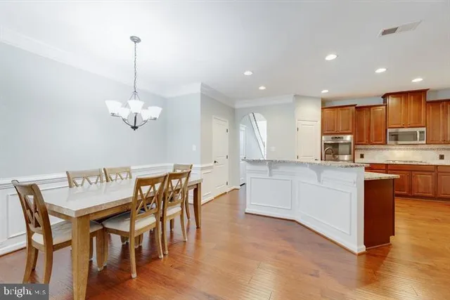 a kitchen with a table chairs and white cabinets