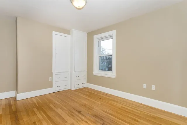 an empty room with cabinet and wooden floor