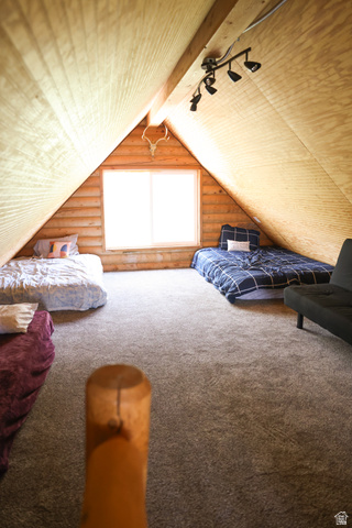 15253 Mill Road, Unit 62 Huntsville, UT 84317 - Photo 29 of 48 Spacious attic room featuring sloped wood-paneled ceilings, a bright central window, track lighting, and soft carpet flooring