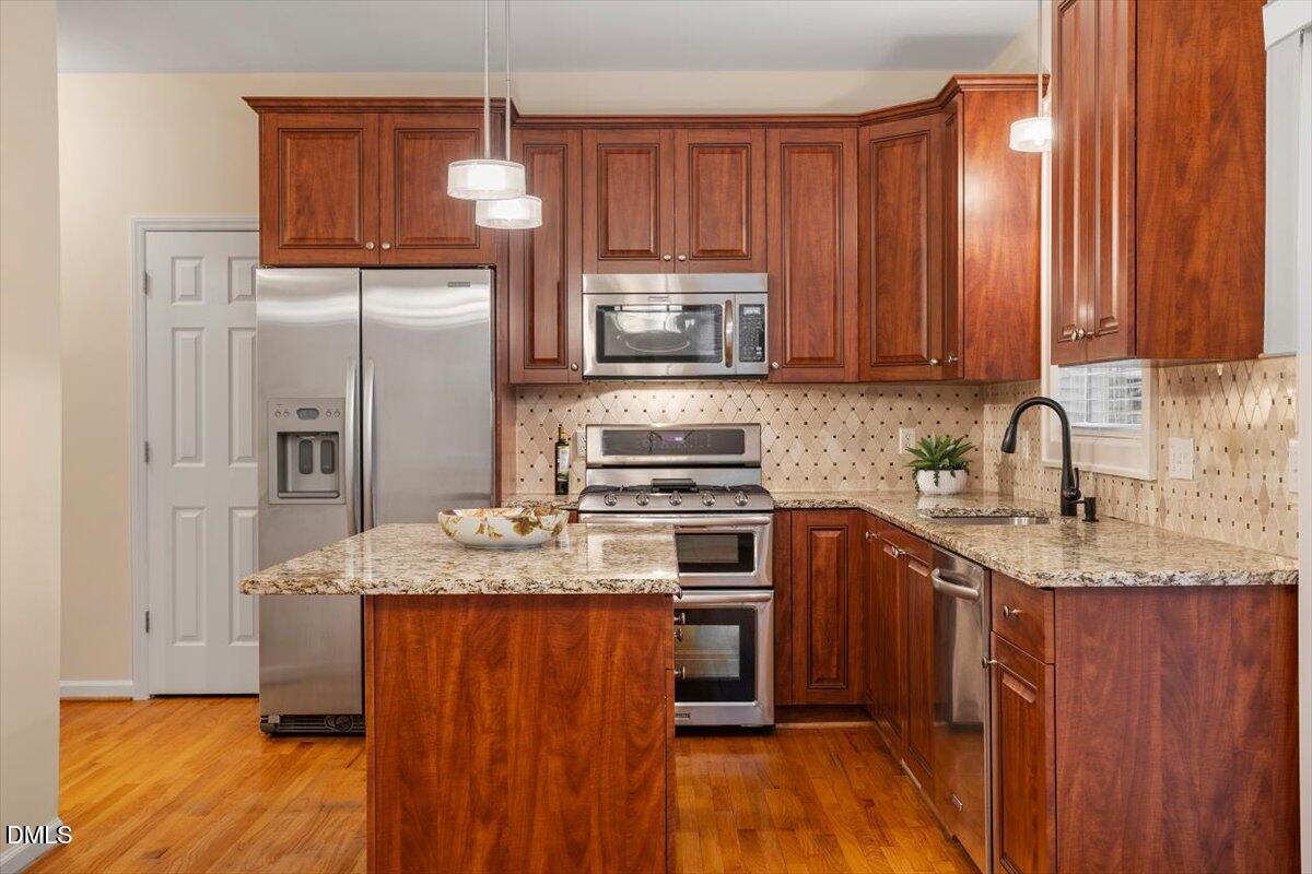 2628 Crofton Springs Drive Raleigh, NC 27615 - Photo 12 of 33 a kitchen with stainless steel appliances granite countertop a stove a sink dishwasher and a refrigerator