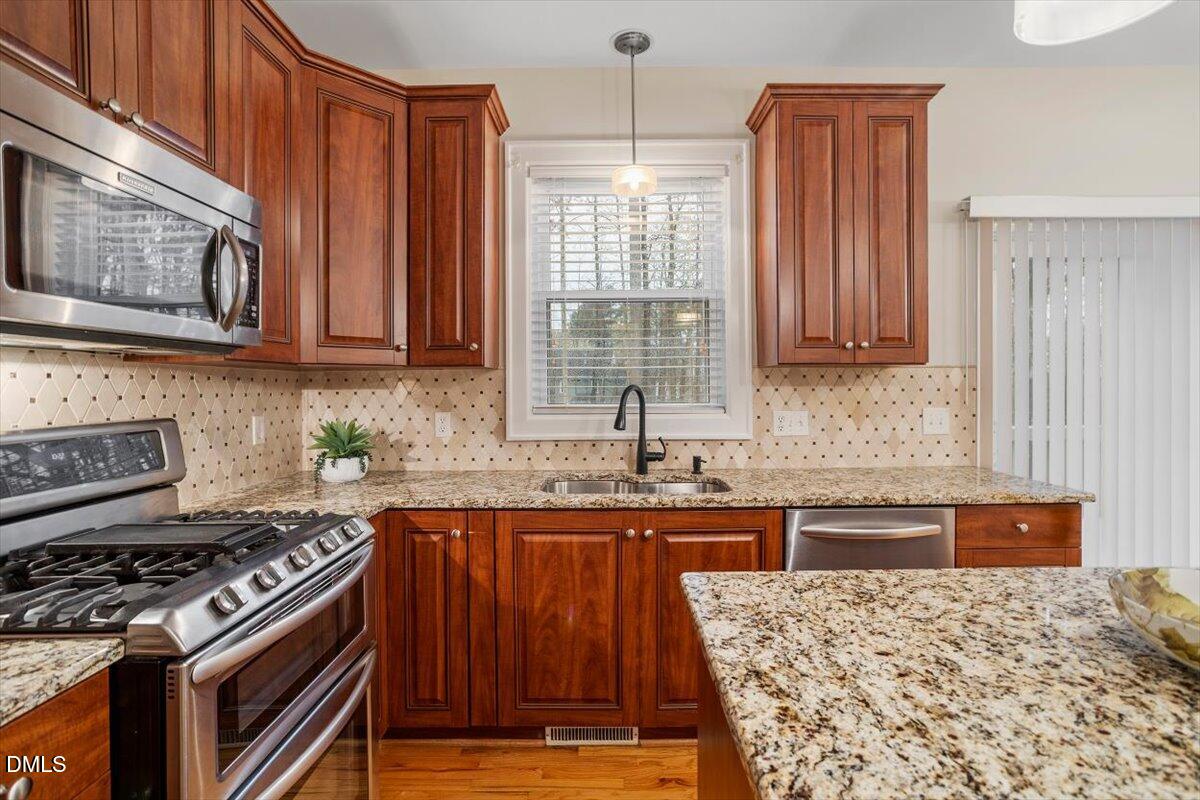 2628 Crofton Springs Drive Raleigh, NC 27615 - Photo 13 of 33 a kitchen with stainless steel appliances granite countertop a stove a sink dishwasher and a refrigerator