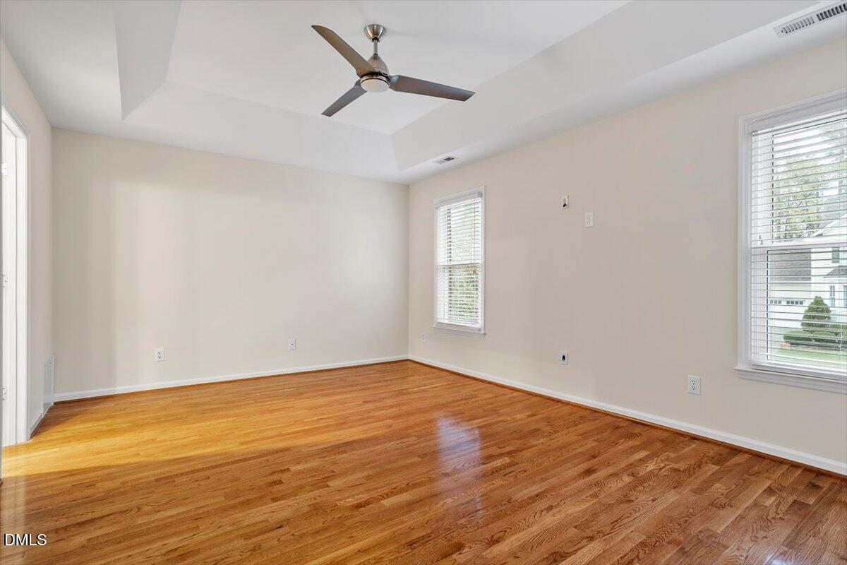 2628 Crofton Springs Drive Raleigh, NC 27615 - Photo 19 of 33 an empty room with wooden floor fan and windows