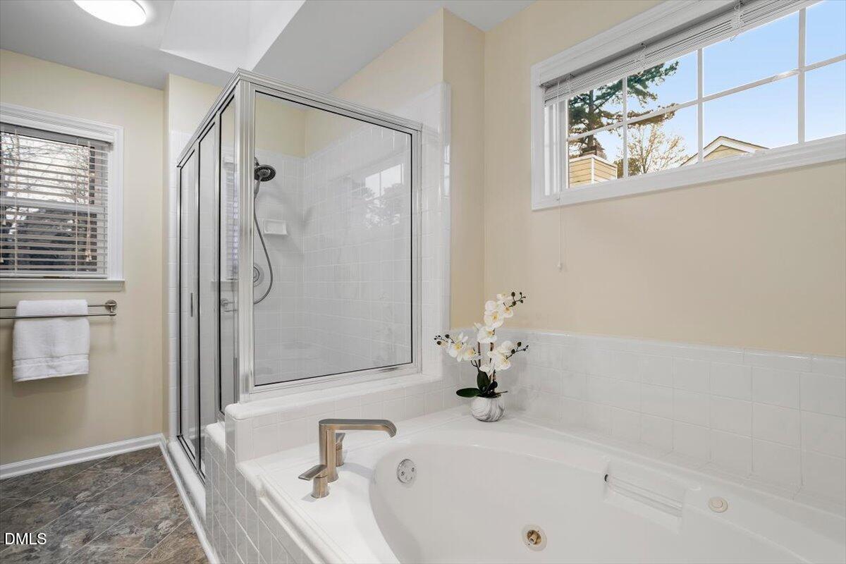 2628 Crofton Springs Drive Raleigh, NC 27615 - Photo 22 of 33 a bathroom with a tub and a shower