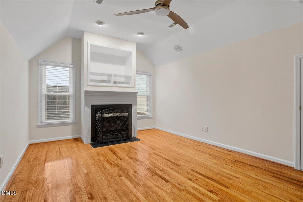 2628 Crofton Springs Drive Raleigh, NC 27615 - Photo 24 of 33 a view of empty room with wooden floor and fireplace