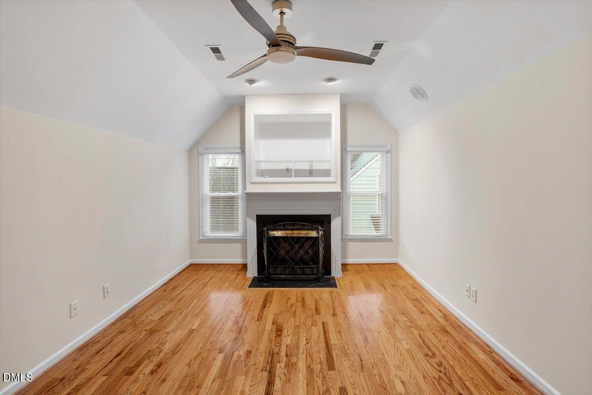 2628 Crofton Springs Drive Raleigh, NC 27615 - Photo 25 of 33 a view of an empty room with wooden floor fireplace and a window