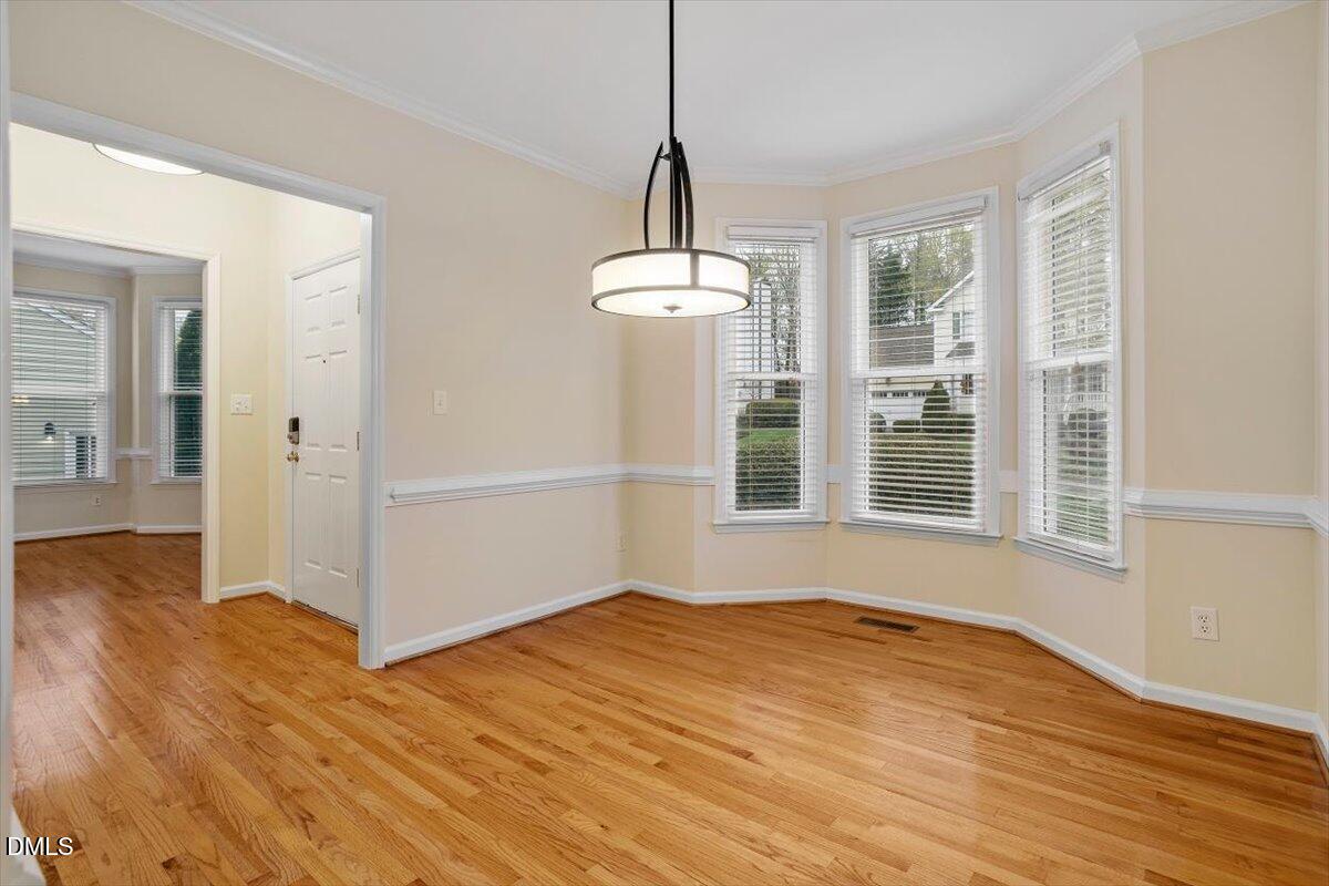 2628 Crofton Springs Drive Raleigh, NC 27615 - Photo 6 of 33 a view of an empty room with wooden floor and a window