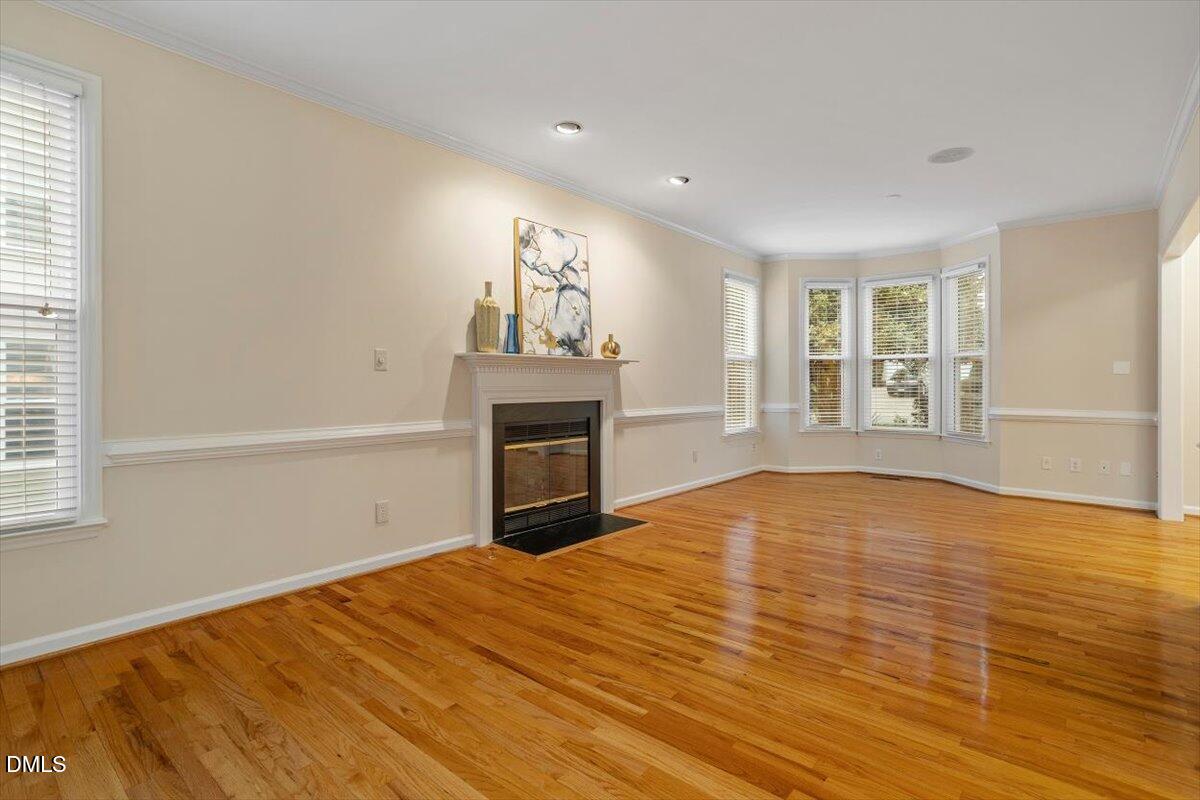 2628 Crofton Springs Drive Raleigh, NC 27615 - Photo 7 of 33 a view of empty room with wooden floor and fireplace