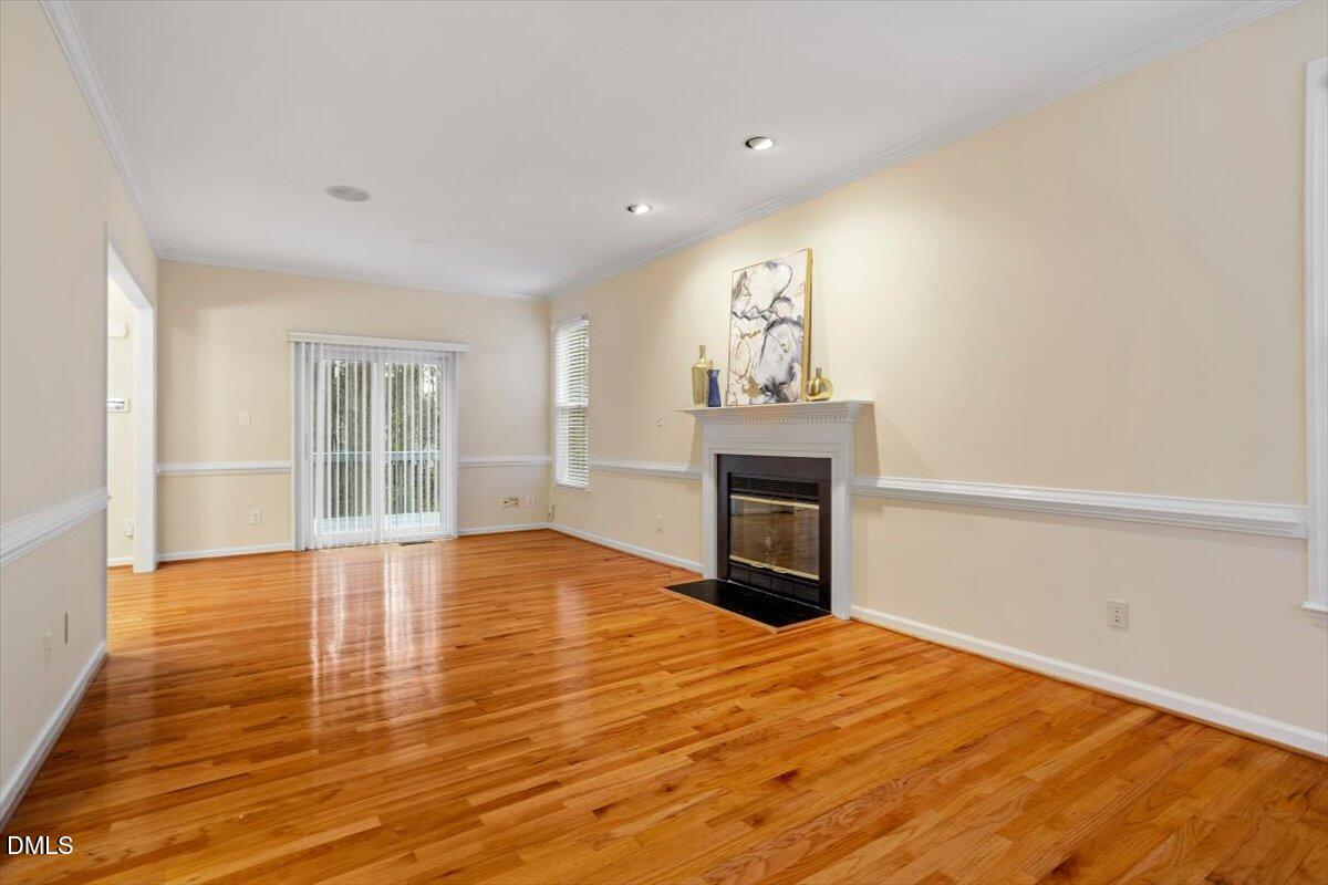 2628 Crofton Springs Drive Raleigh, NC 27615 - Photo 8 of 33 a view of empty room with wooden floor and fireplace