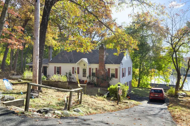 a front view of a house with garden and trees