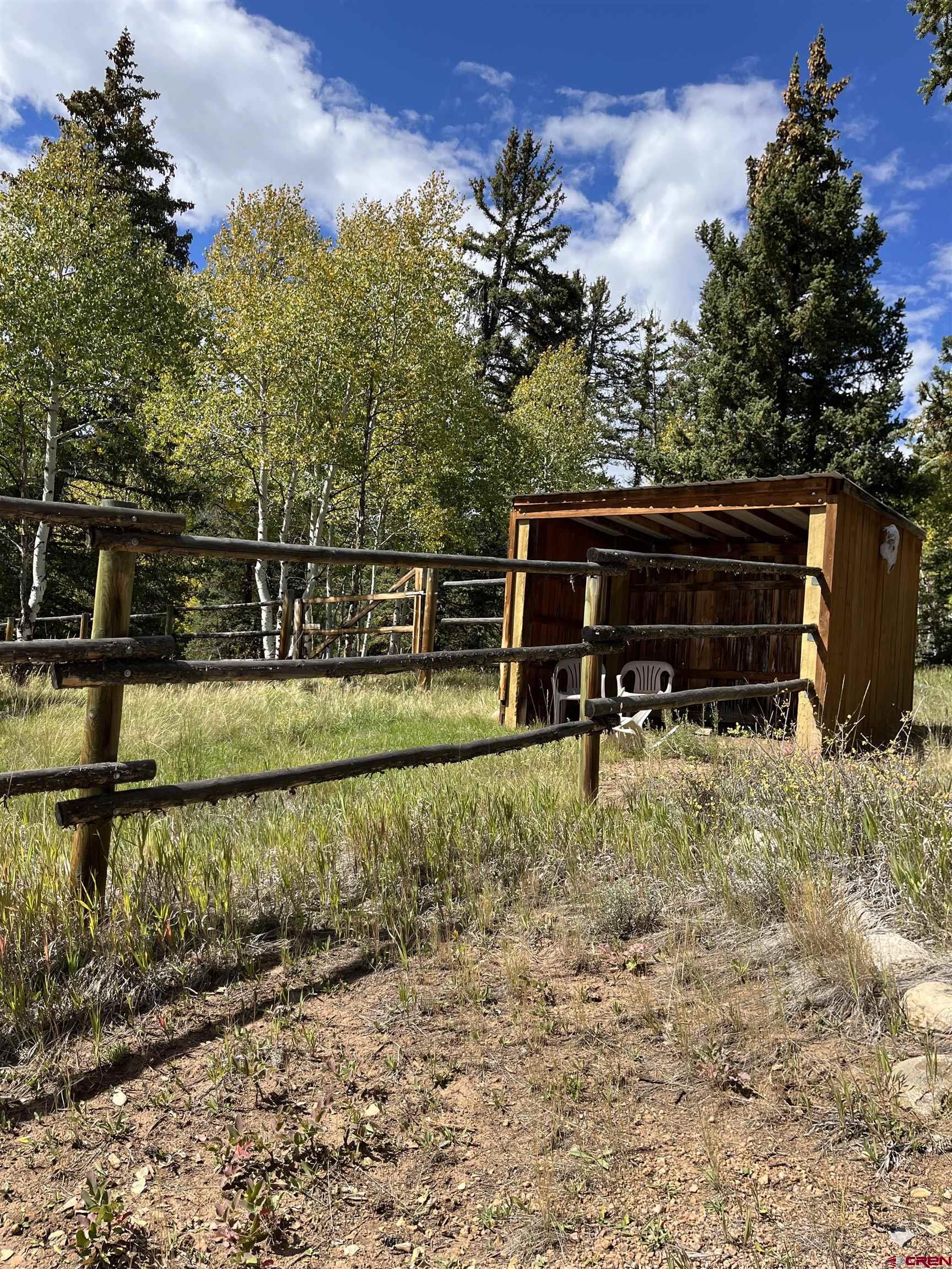 320 Forest Service Road Pitkin, CO 81241 - Photo 14 of 16 a backyard of a house with wooden fence and large trees