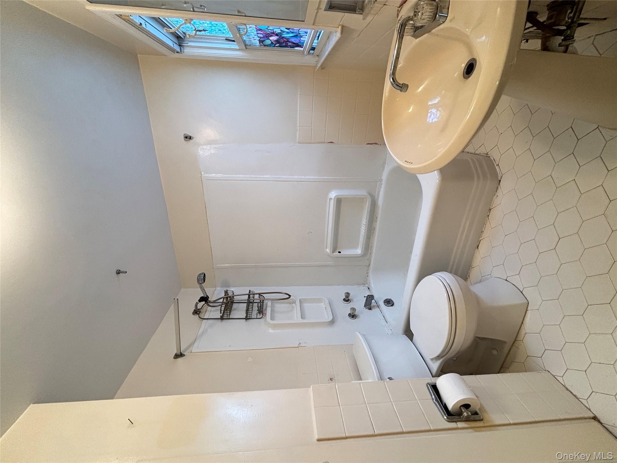 45 John Street New Rochelle, NY 10805 - Photo 10 of 14 a bathroom with a sink a toilet and bathtub