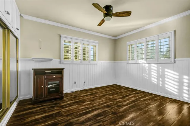a view of an empty room with a window and a kitchen