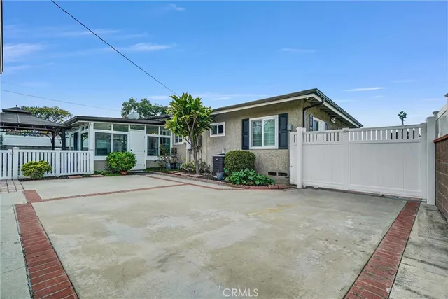 a front view of a house with a yard and potted plants