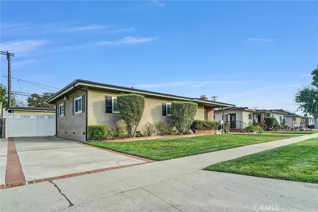 a front view of a house with a yard and potted plants