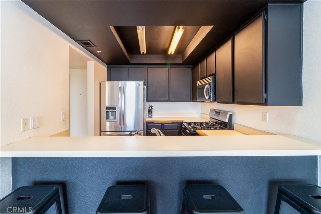 550 Orange Avenue, Unit 318 Long Beach, CA 90802 - Photo 11 of 25 a kitchen with a sink cabinets and stainless steel appliances