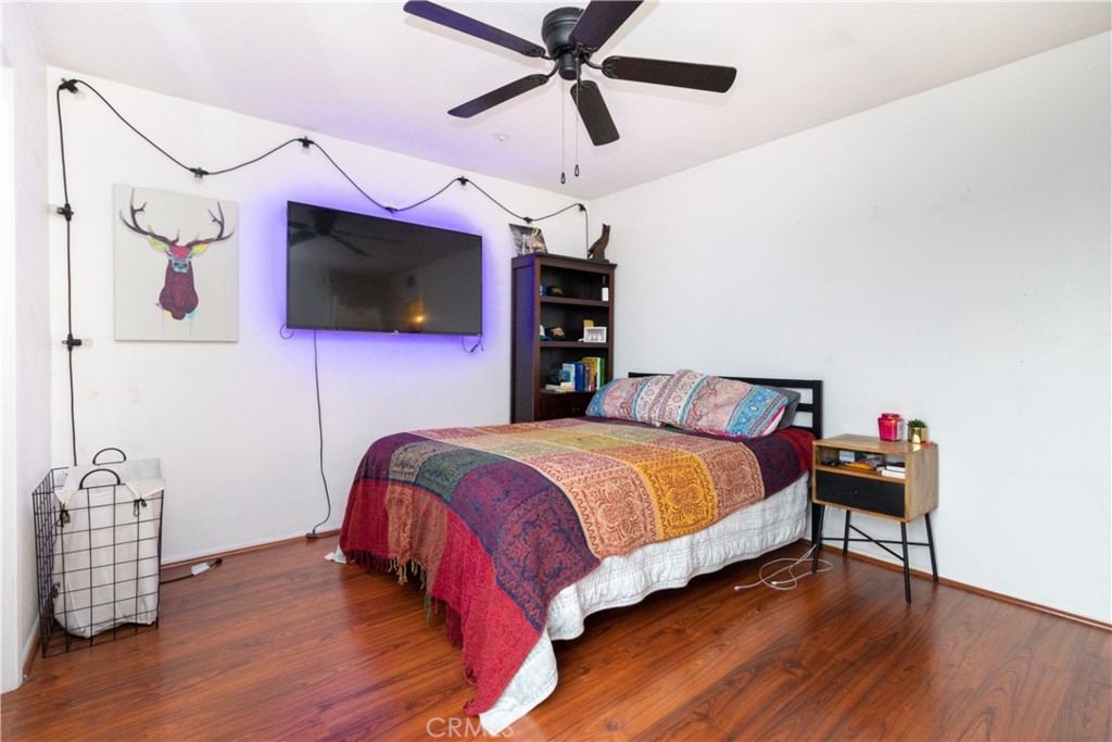 550 Orange Avenue, Unit 318 Long Beach, CA 90802 - Photo 3 of 25 a bedroom with a bed a flat screen tv and a chandelier