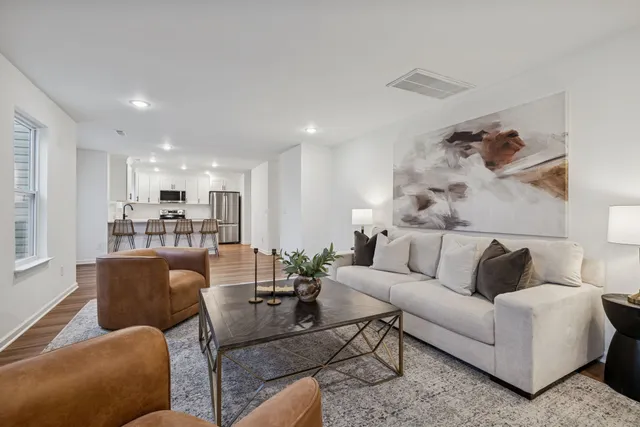 a kitchen with stainless steel appliances a refrigerator a stove top oven and a center island with wooden floor