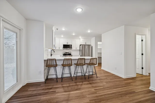 a kitchen with stainless steel appliances a dining table and chairs