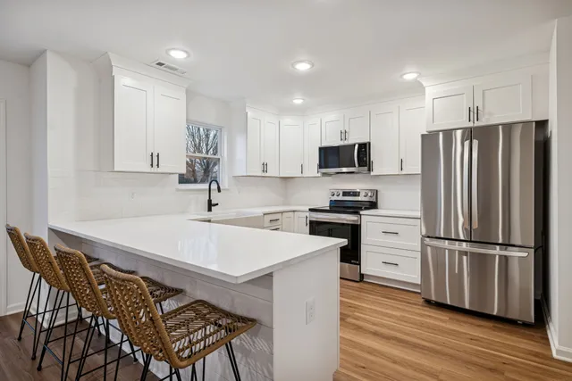 a kitchen with a refrigerator stove and white cabinets