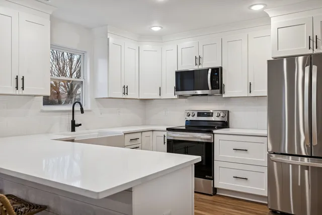 a kitchen with stainless steel appliances white cabinets and a sink