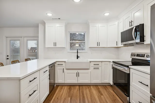 a kitchen with stainless steel appliances granite countertop a stove microwave and oven