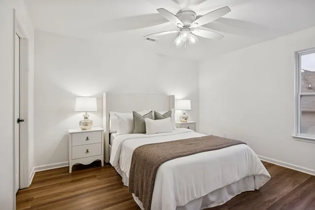 a bedroom with a bed large window and a chandelier